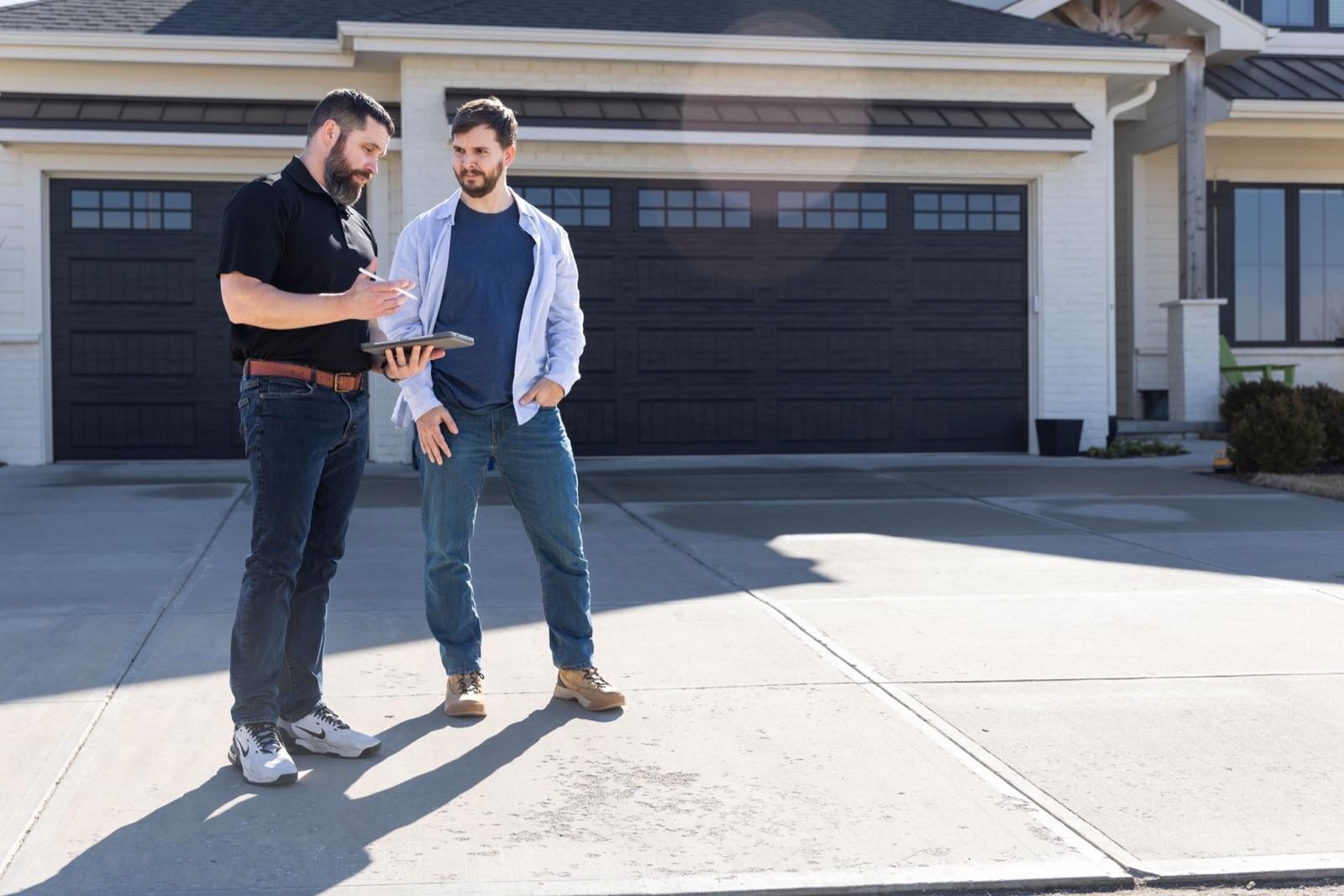 A rep and a homeowner talking in the driveway at the start of the appointment